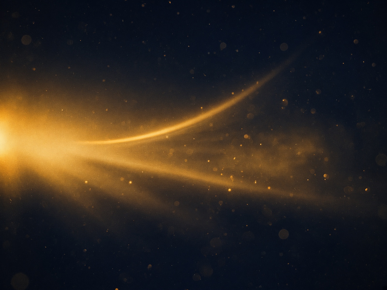 Anamorphic gold light flaring through deep navy darkness.